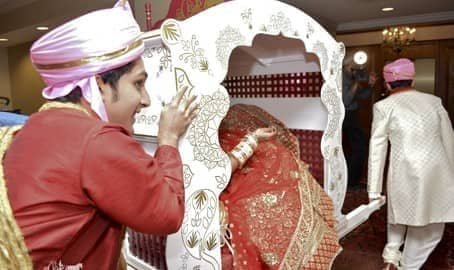 Bride seated in decorative Indian wedding doli at a South Asian wedding ceremony in Pittsburgh PA